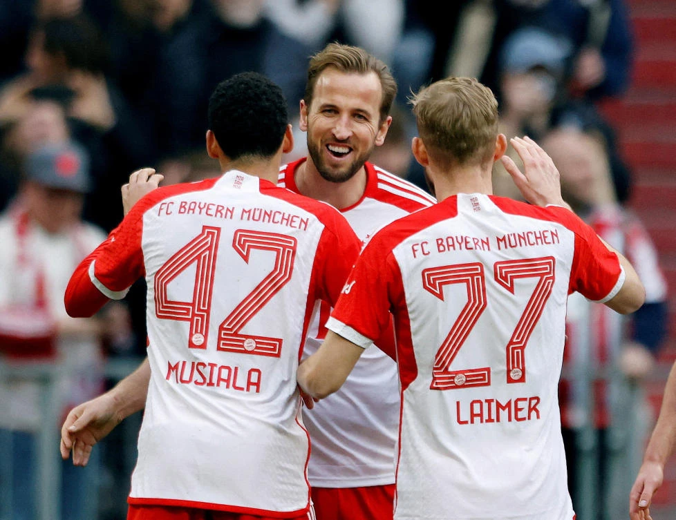Bayern Munich’s Harry Kane celebrates scoring their seventh goal to complete his hat-trick with Jamal Musiala and Konrad Laimer during their Bundesliga match against FSV Mainz 05 at Allianz Arena, Munich, on Mar. 9, 2024. (Reuters)