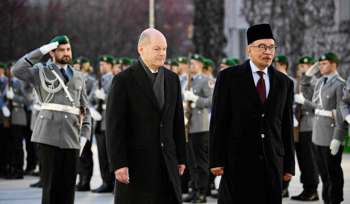 German Chancellor Olaf Scholz (L) and Malaysian Prime Minister Anwar Ibrahim review a military honour guard during an official welcoming ceremony prior to talks at the Chancellery in Berlin on March 11, 2024. (AFP)