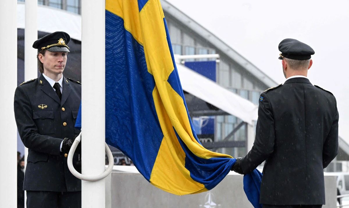 Officials prepare to hoist the Swedish national flag on a pole during a flag raising ceremony for Sweden's accession to NATO at the North Atlantic Alliance headquarters in Brussels, on March 11, 2024. (AFP)