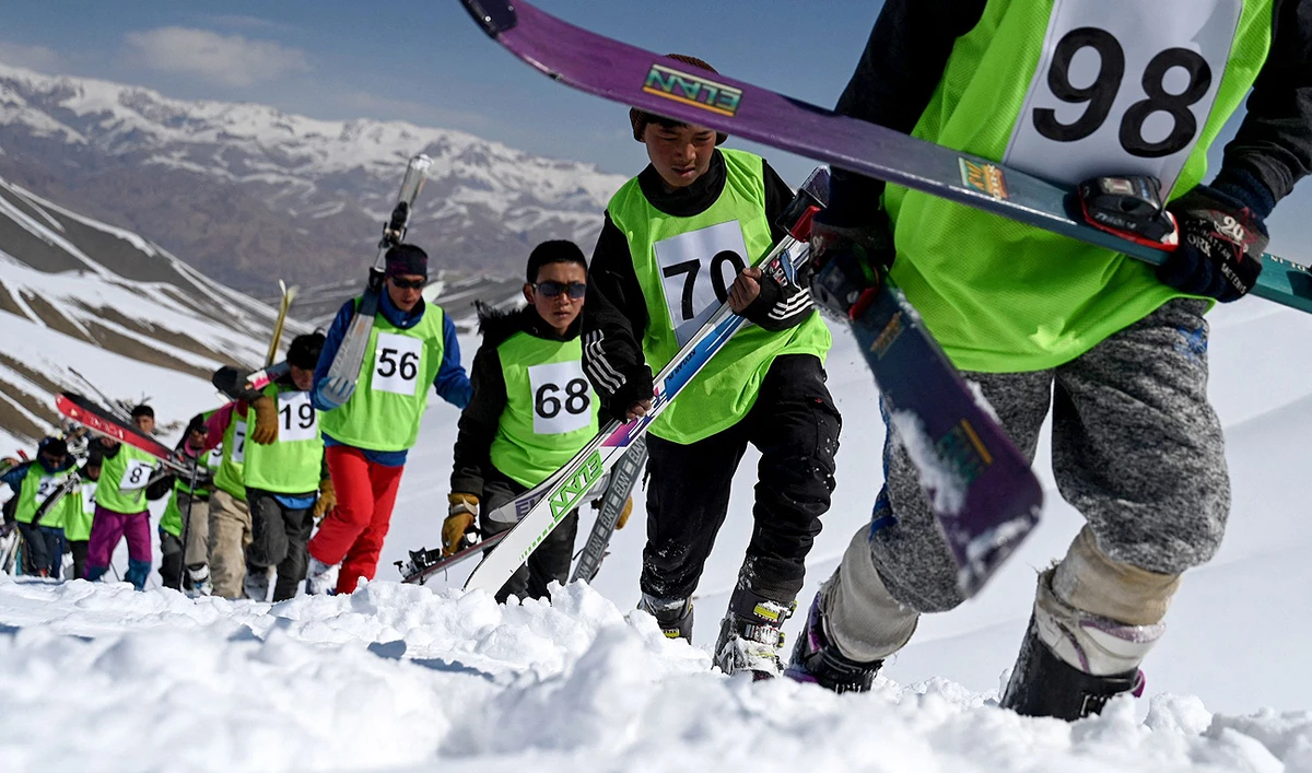 Afghan skiers walk uphill to compete in a ski race on the outskirts of Bamiyan province on March 8, 2024. (AFP)