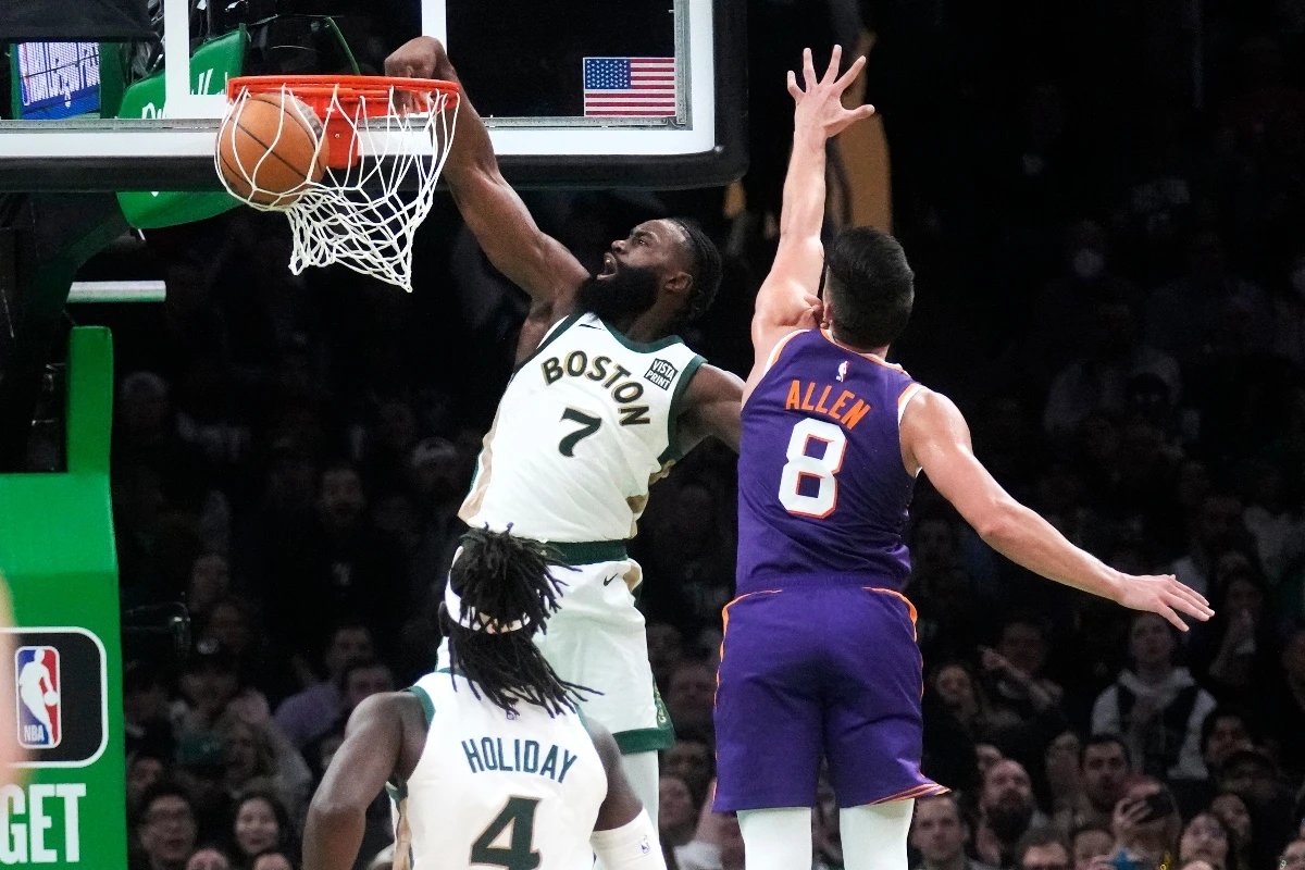 Boston Celtics guard Jaylen Brown dunks after driving past Phoenix Suns guard Grayson Allen during the second half of an NBA basketball game Thursday in Boston. (AP)