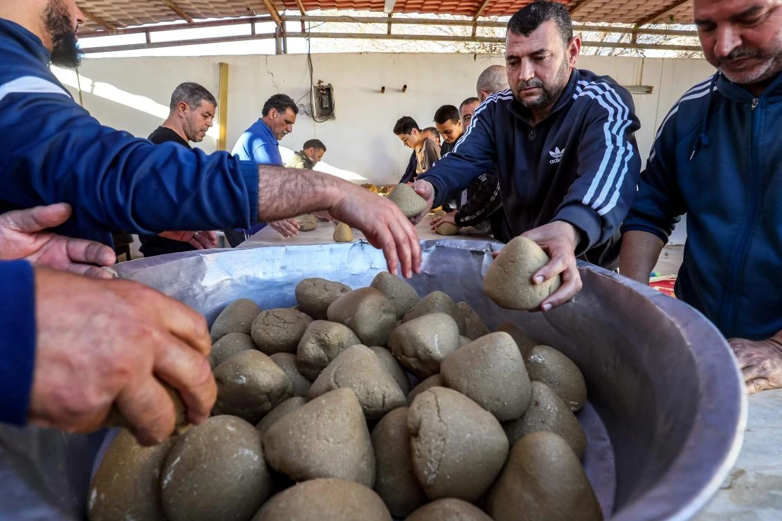 Volunteers prepare portions of the traditional Libyan dish "Bazin", which consists of a dough made with barley, water, and salt in the coastal city of Tajura east of Tripoli on March 13, 2024, to be distributed to needy families during the Muslim holy fasting month of Ramadan. (AFP)