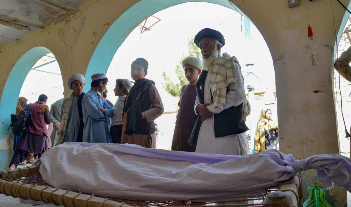 Relatives stand around the dead body of a victim of a suicide bomb attack during a funeral ceremony at a mosque in Kandahar on March 21, 2024. (AFP)