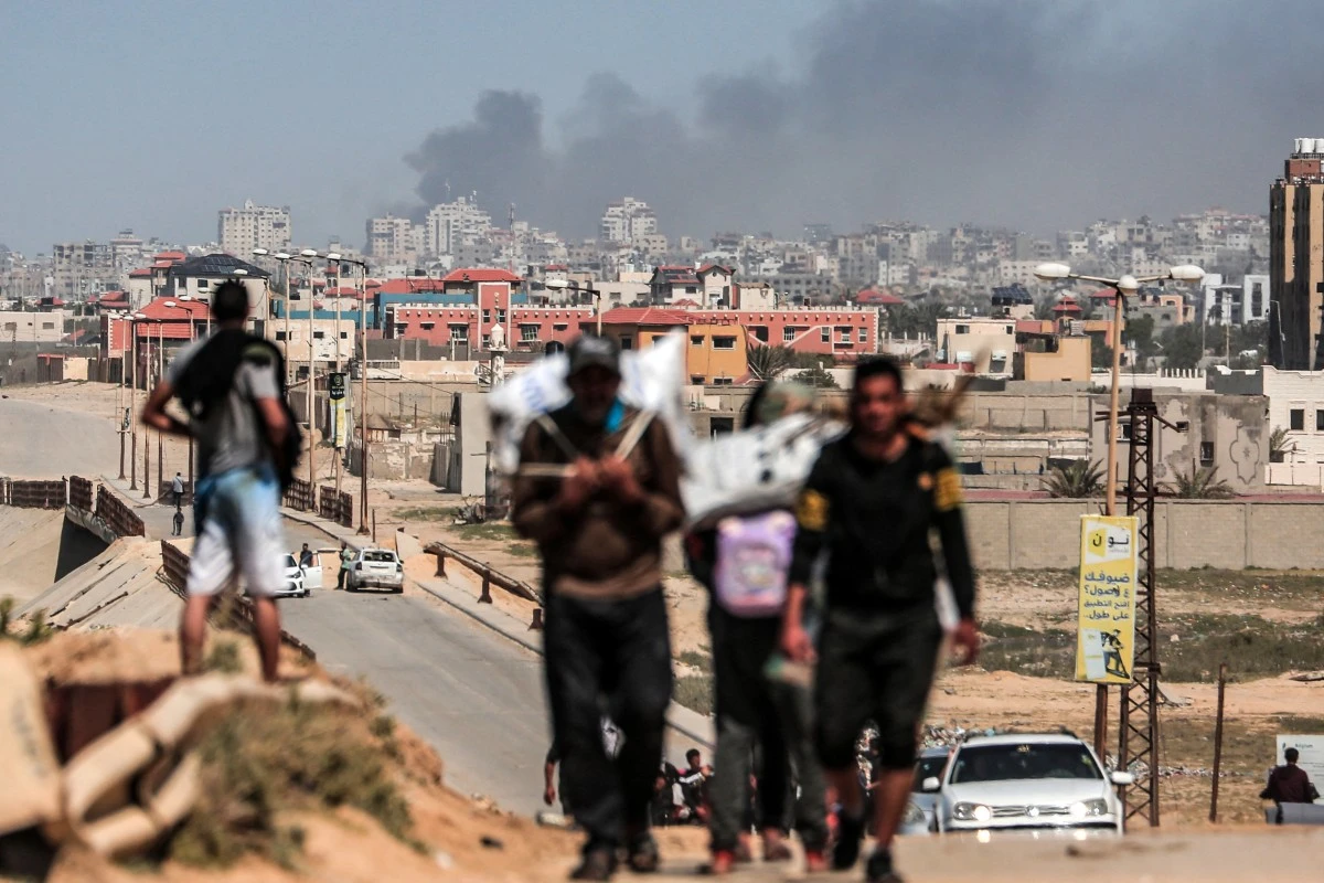 People flee as smoke rises above buildings near the Al-Shifa hospital compound and its vicinity. (AFP)