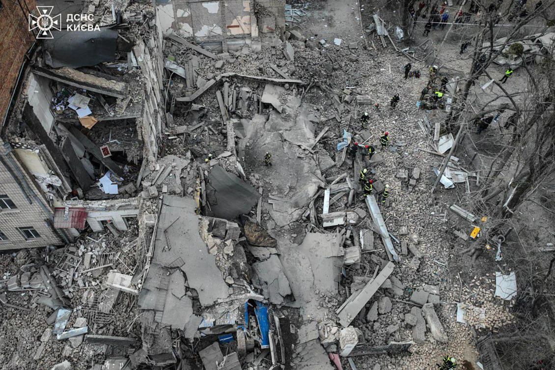 This handout photograph taken and released by Ukrainian Emergency Service on Mar. 25, 2024, shows rescuers working at the site of a missile attack in Kyiv. (AFP)