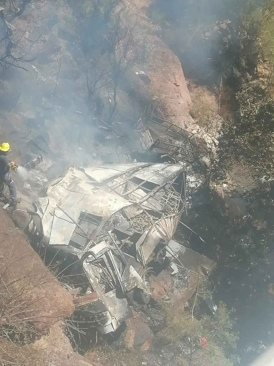 Firefighters hose down a bus after it crashed off the road in Waterberg District, Limpopo Province, South Africa, on March 28, 2024, in this image taken from social media. (Reuters)