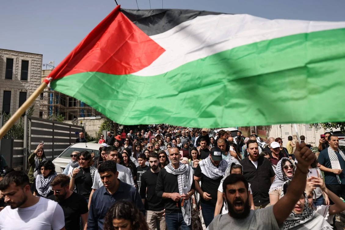 People wave Palestinian national flags during a rally marking the 48th anniversary of Land Day, in the Arab-Israeli town of Deir Hanna in the northern Galilee region on Mar. 30, 2024. (AFP)