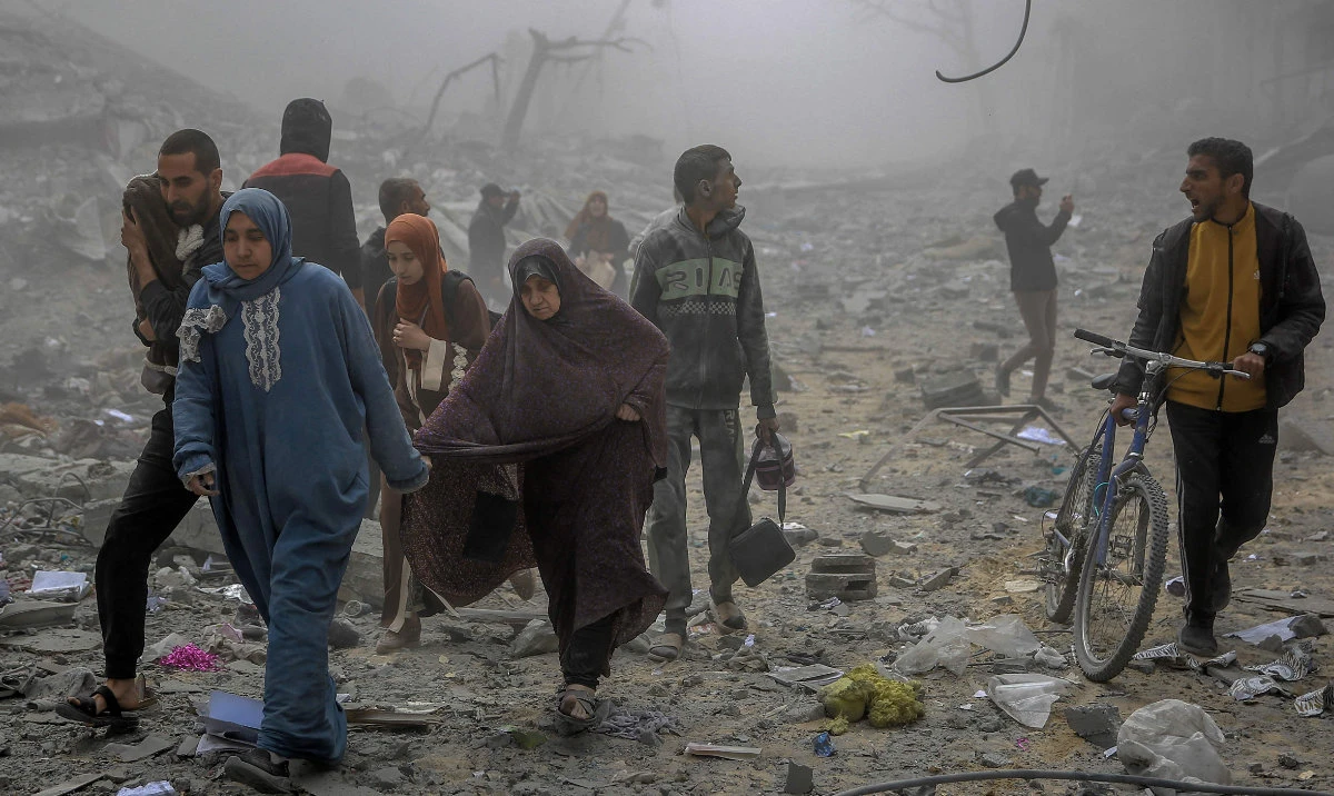 Palestinians flee the area after Israeli bombardment in central Gaza City on March 18, 2024. (AFP)