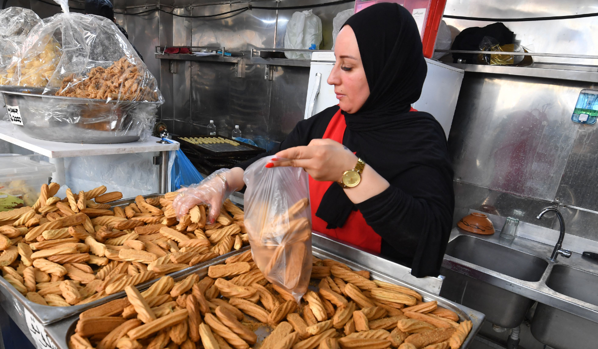 An employee serves pastry to a customer at a bakery in Tunis during the Muslim holy fasting month of Ramadan on March 29, 2024, amid a shortage of sugar supplies in the country. (AFP)
