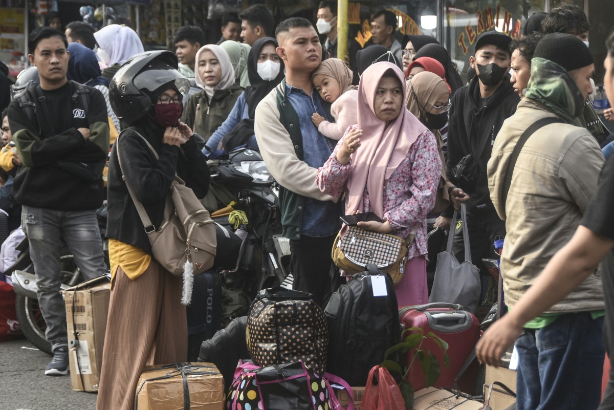 Travelers wait for long-distance buses as they return to their hometowns ahead of Eid Al-Fitr, which marks the end of the Muslim holy fasting month of Ramadan, in Bekasi, near Jakarta, on April 6, 2024. (AFP)