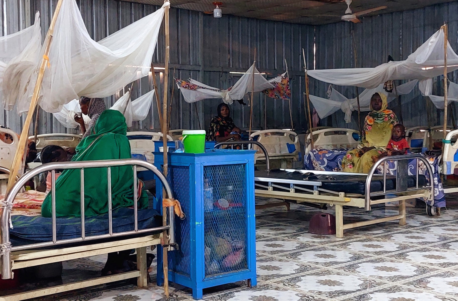 Women and a children sit waiting at a nutrition centre at the Kalma camp for the displaced just outside Nyala, the provincial capital of South Darfur state, on November 20, 2022. (AFP file photo)