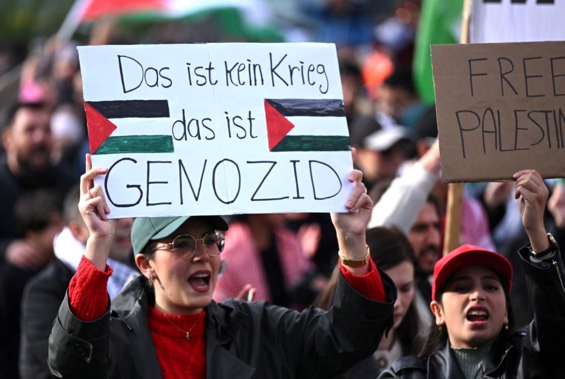 A protester holds a placard with the lettering reading 'This is no war, this is genocide' during a 'March for Palestine' in Dortmund, western Germany on October 28, 2023, to call for a ceasefire in the war between Israel and Hamas. (File/AFP)