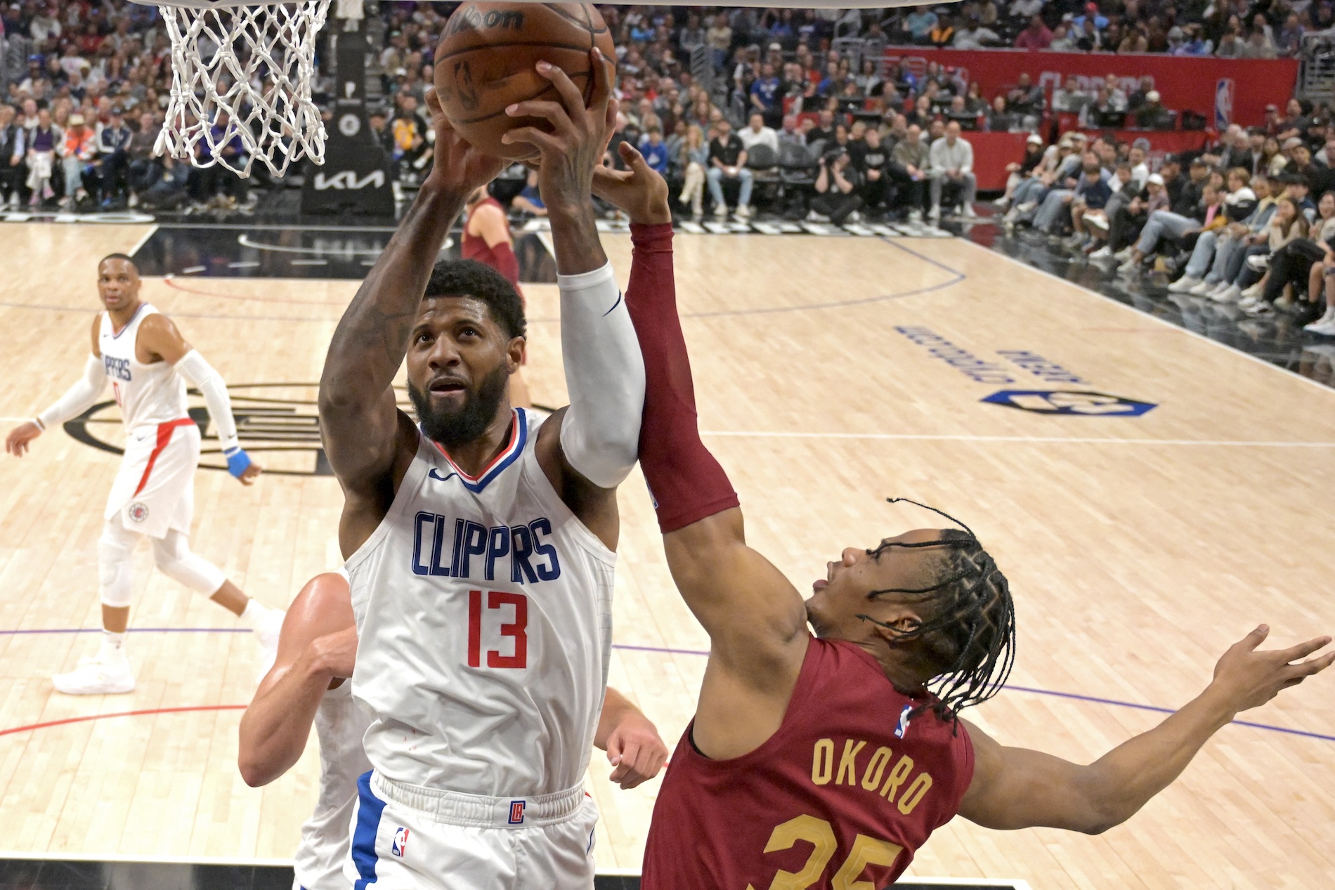 Los Angeles Clippers forward Paul George reaches in front of Cleveland Cavaliers forward Isaac Okoro for a rebound in the second half of an NBA game at Crypto.com Arena Sunday. (USA TODAY Sports)