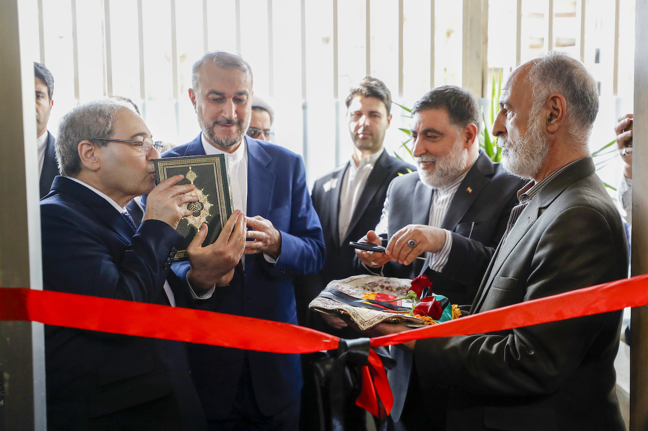 Syrian FM Faisal Mekdad kisses a copy of the Quran as he attends with Iranian FM Hossein Amirabdollahian, the opening ceremony of the new Iranian consulate building in Damascus, Syria, Monday, April 8, 2024. (AP)