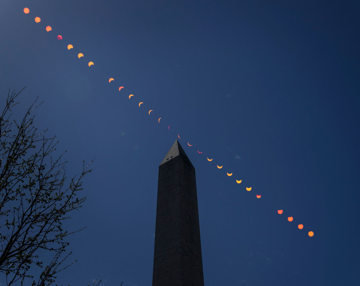 This composite image of multiple exposures shows the progression of a partial solar eclipse over the Washington Monument in the US capital on April 8, 2024. (NASA via AP)