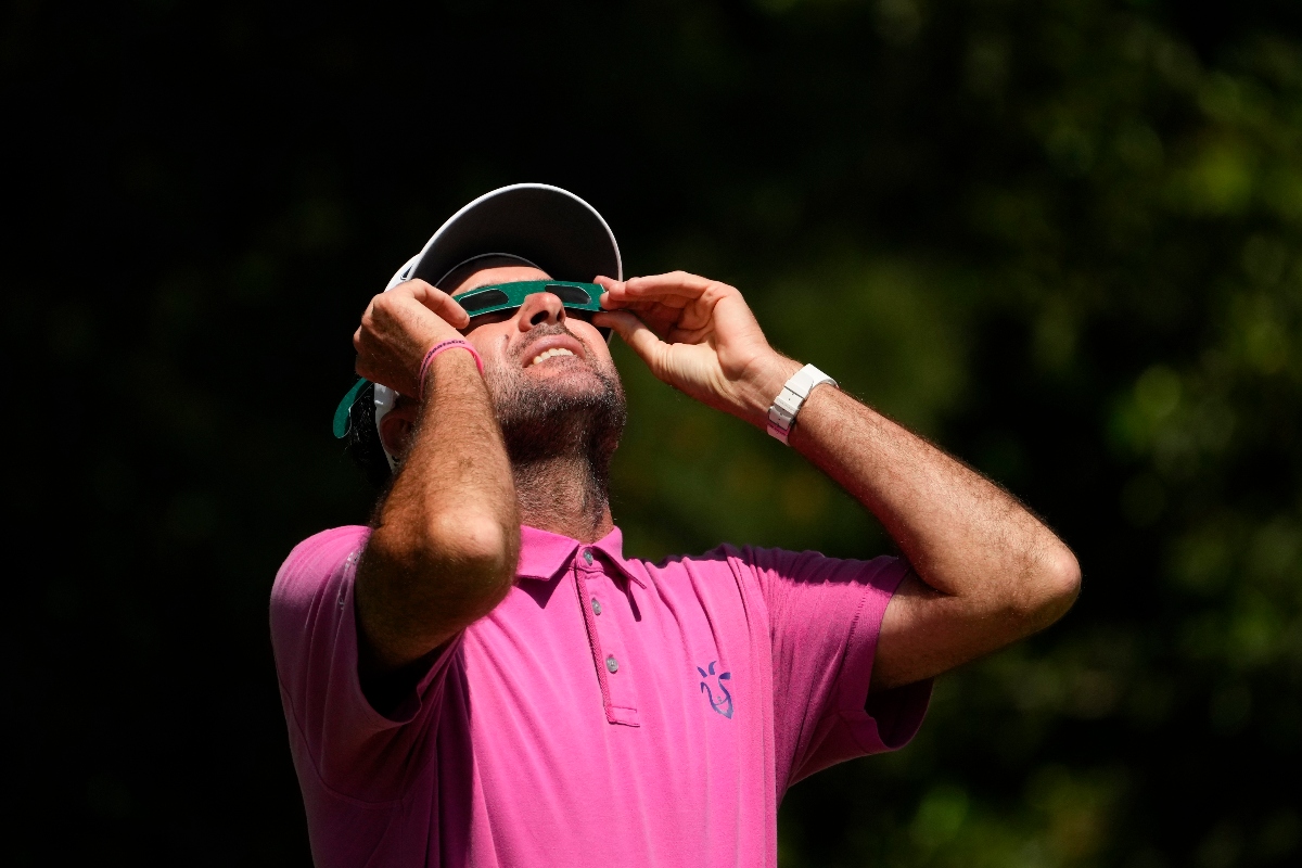 Bubba Watson looks up at the sun during a solar eclipse while standing on the first hole during a practice round in preparation for the Masters golf tournament at Augusta National Golf Club Monday in Augusta, Ga. (AP)