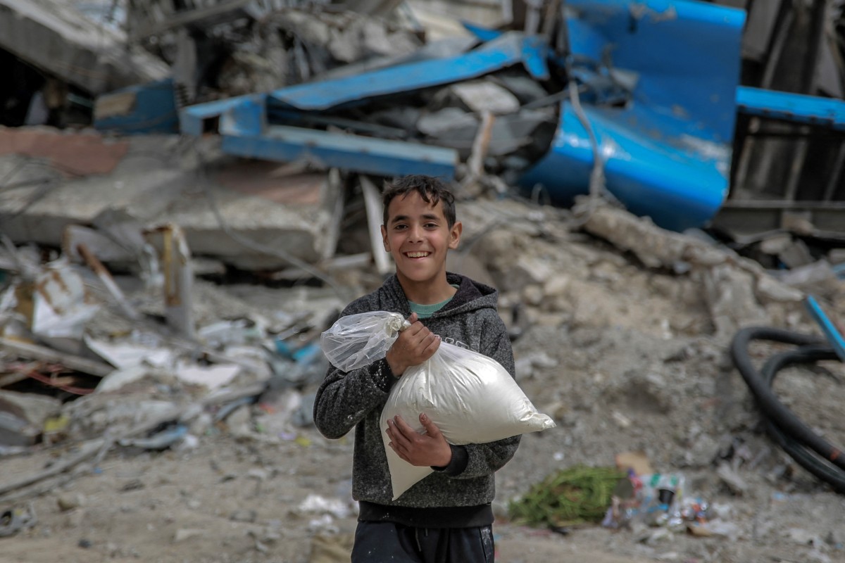 A boy carries a bag of flour after humanitarian aid was distributed in Gaza City on March 17, 2024, amid ongoing battles between Israel and the militant group Hamas. (File/AFP)