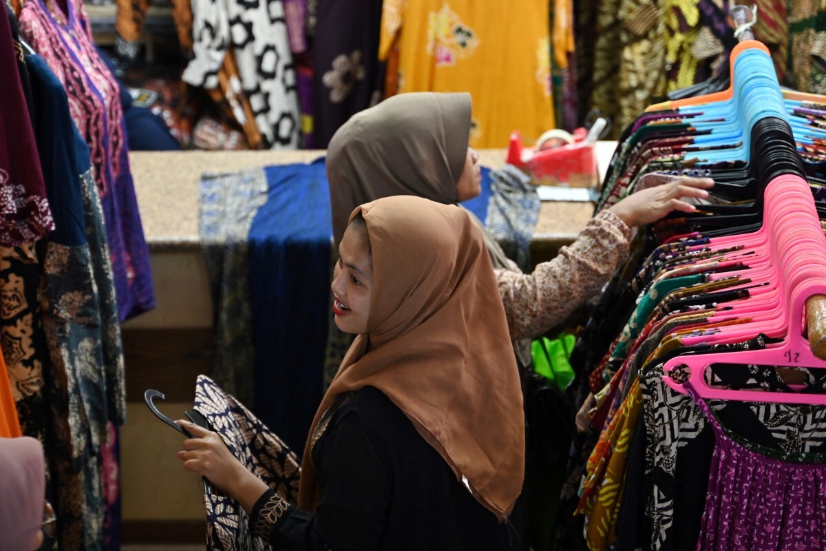 People shop for Eid Al-Fitr celebration at the Tanah Abang textile market in Jakarta on April 3, 2024. (AFP