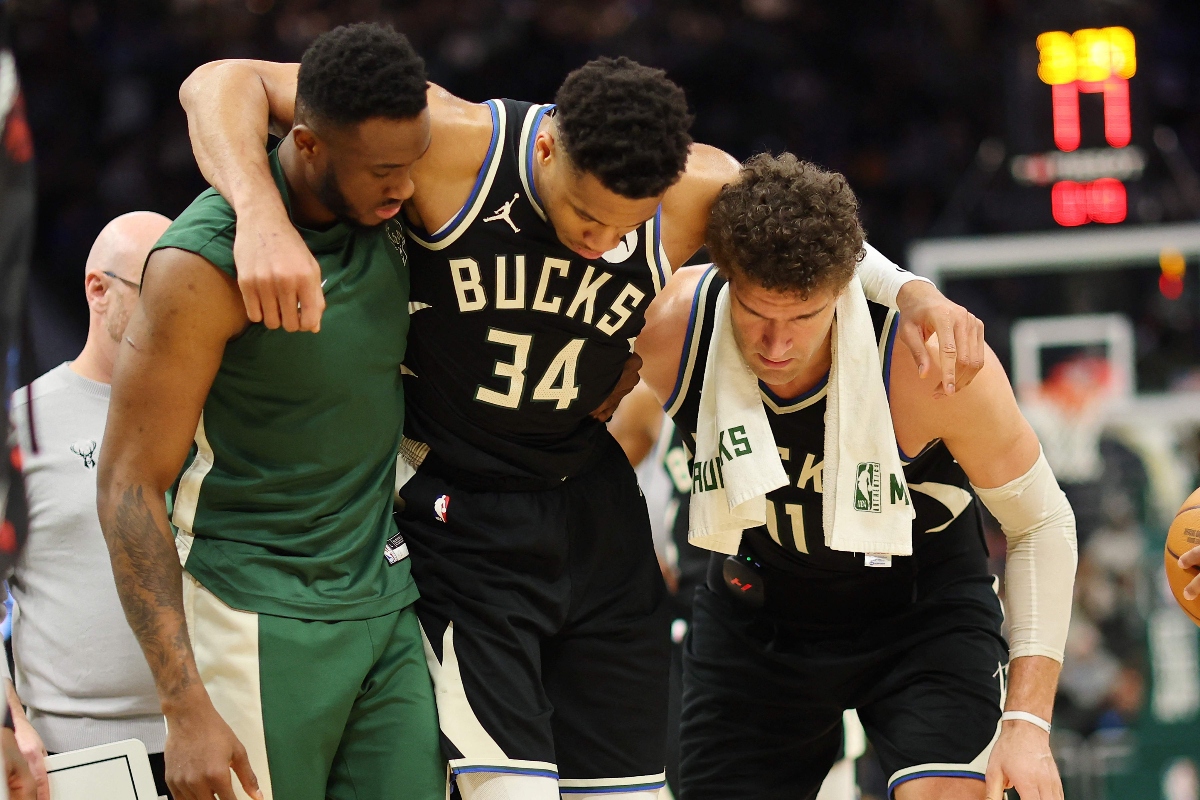 Giannis Antetokounmpo of the Milwaukee Bucks is helped off the court by Thanasis Antetokounmpo and Brook Lopez #11 after suffering an injury during the second half of a game against Boston Celtics at Fiserv Forum on April 9, 2024 in Milwaukee, Wisconsin. (GETTY IMAGES NORTH AMERICA/AFP)
