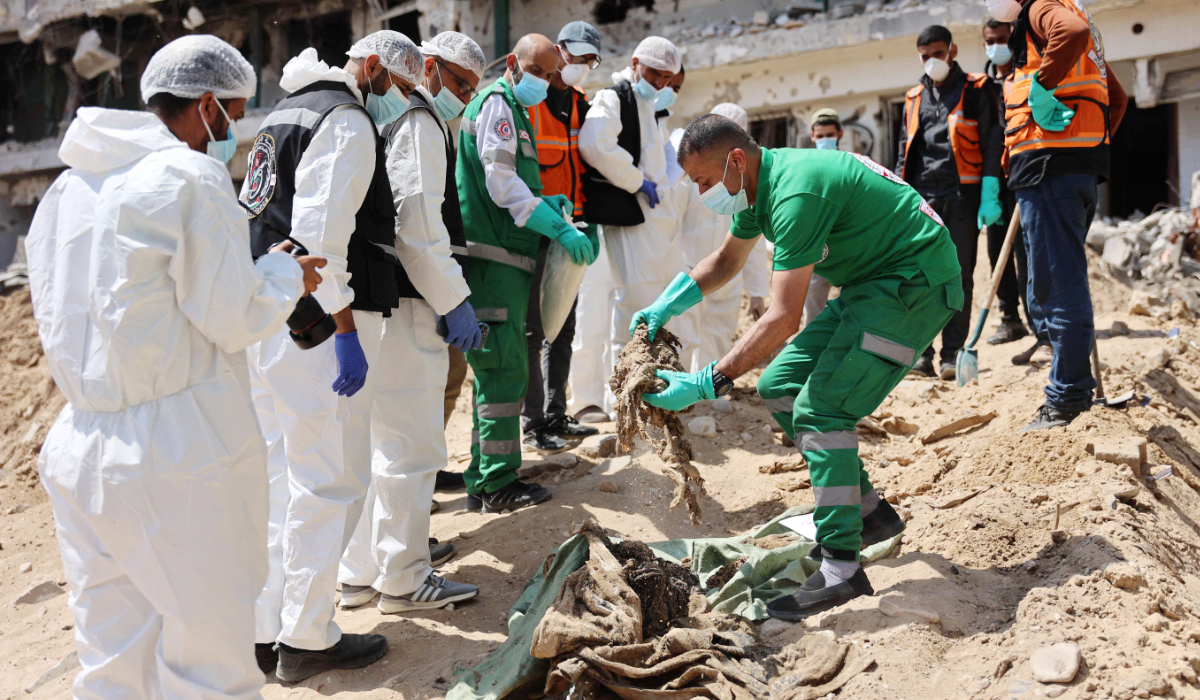 Palestinian forensic and civil defense teams recover human remains at the grounds of Al-Shifa Hospital. (AFP)
