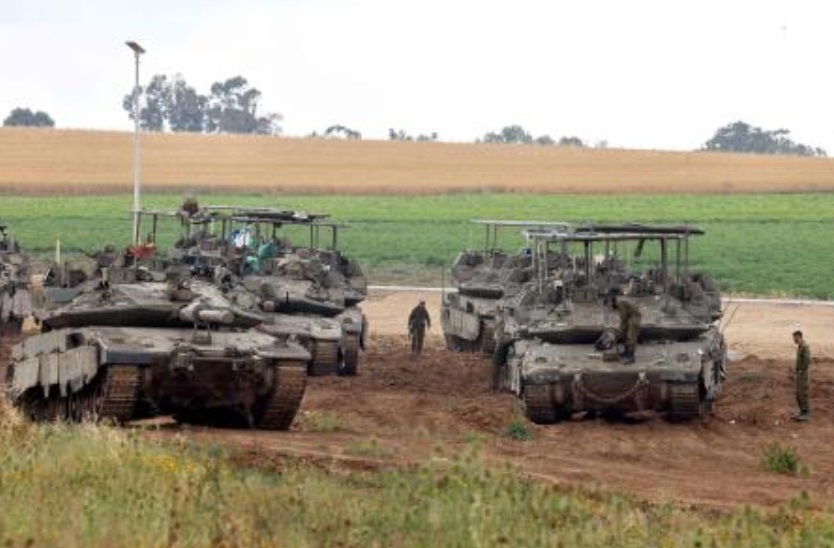 Israeli army troops stand around their tank in an area along the border with the Gaza Strip in southern Israel on Apr. 10, 2024. (AFP)