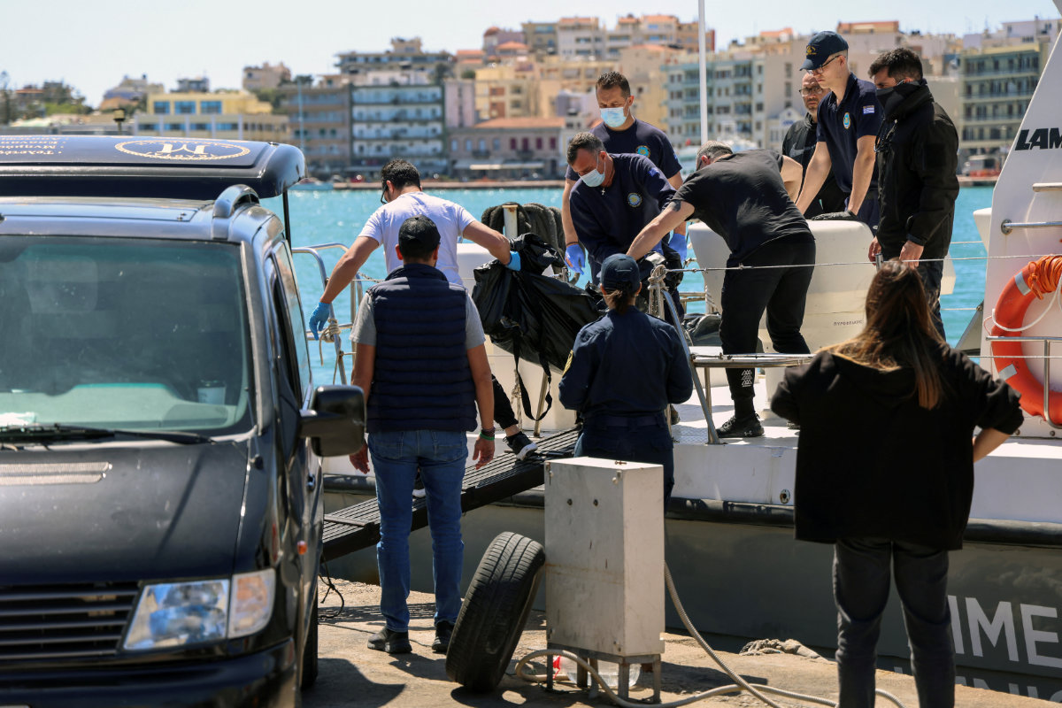 Greek coast guard officers carry the covered body of a migrant, following a shipwreck on the island of Chios, Greece, on April 10, 2024. (REUTERS)