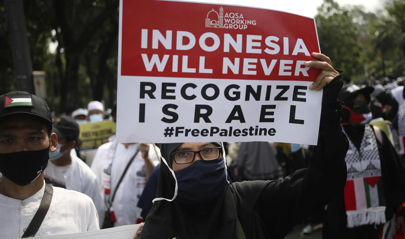 An Indonesian woman holds up a poster during a rally against Israel’s attacks on Gaza, outside the US embassy in Jakarta on May 21, 2021. (AP/File)