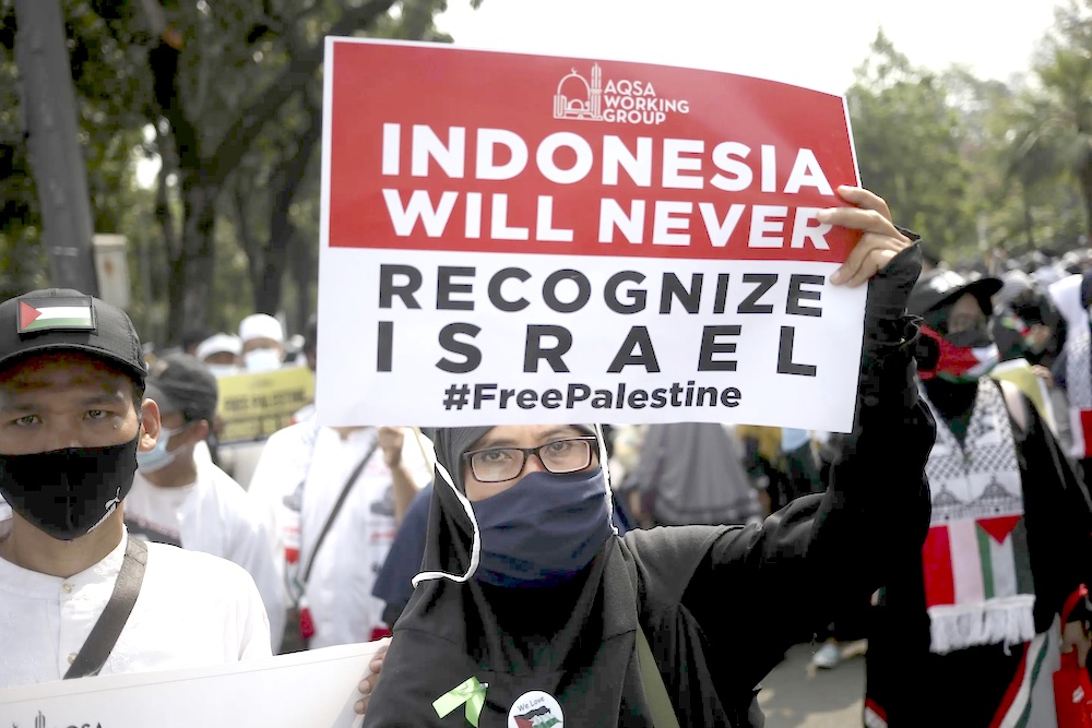 An Indonesian woman holds up a poster during a rally against Israel’s attacks on Gaza, outside the US embassy in Jakarta on May 21, 2021. (AP)