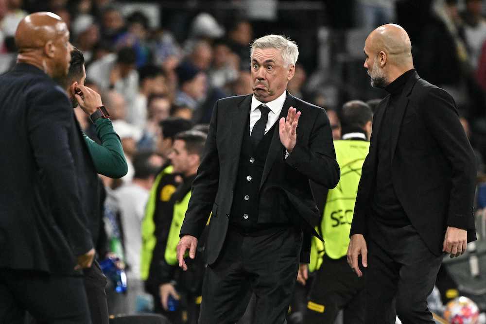 Real Madrid’s coach Carlo Ancelotti gestures next to Manchester City’s manager Pep Guardiola, right, during the UEFA Champions League quarterfinal first leg between Real Madrid and Manchester City in Madrid on April 9, 2024. (AFP)