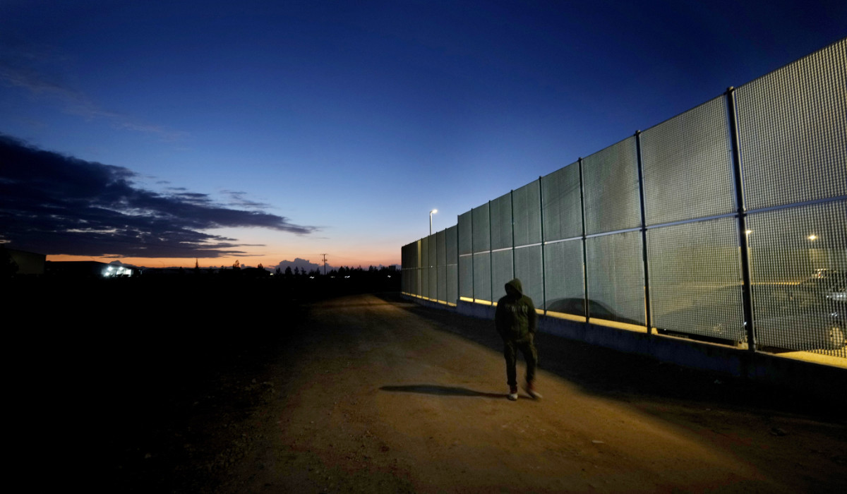 A man walks by the fence at the Pournara migrant reception center in Kokkinotrimithia outside of capital Nicosia, Cyprus, on Jan. 24, 2024. (AP)