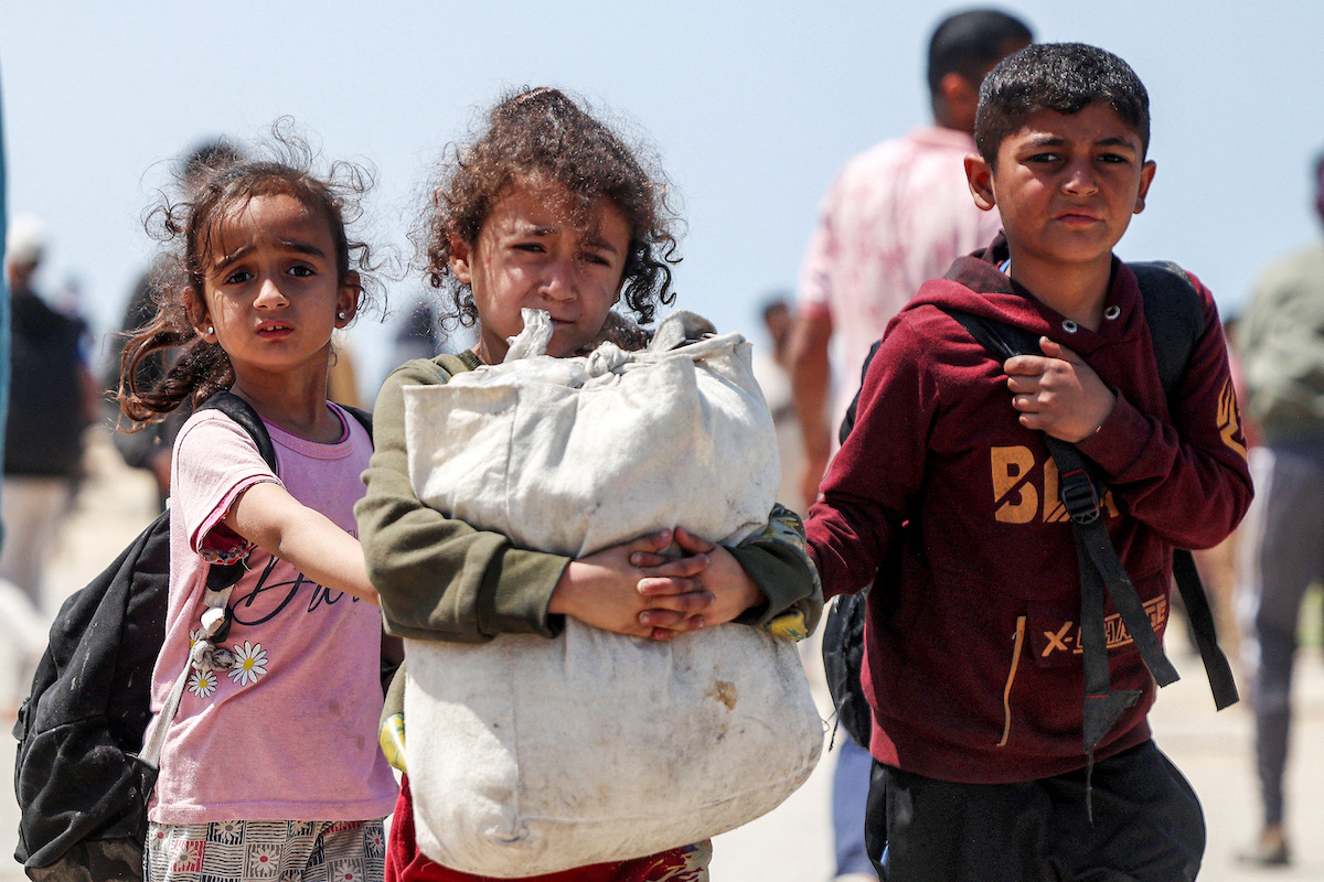 Children walk with other displaced Palestinians taking the coastal Rashid road to return to Gaza City as they pass through Nuseirat in the central Gaza Strip. (File/AFP)