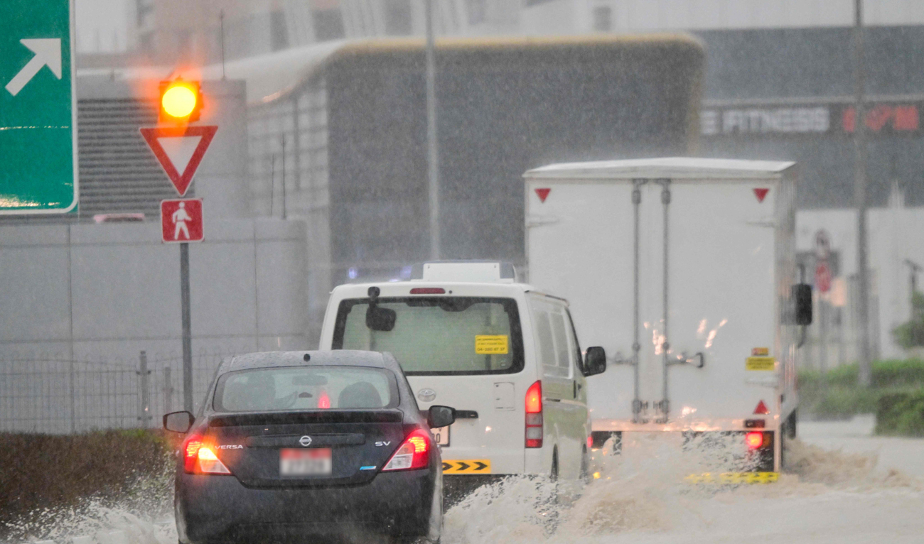 Vehicles drive on a flooded road during torrential rain in the Gulf Emirate of Dubai on April 16, 2024. (AFP)