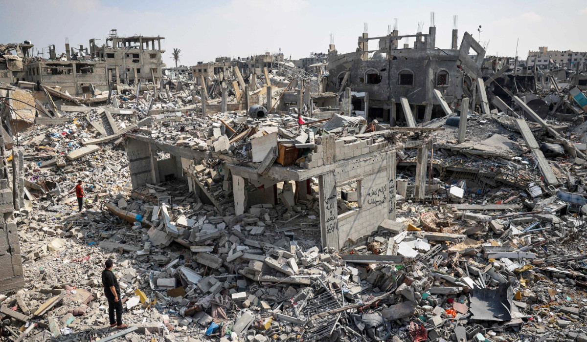 People inspect the damage amid the rubble of buildings destroyed during Israeli bombardment in Khan Yunis in the southern Gaza Strip on April 16, 2024. (AFP)