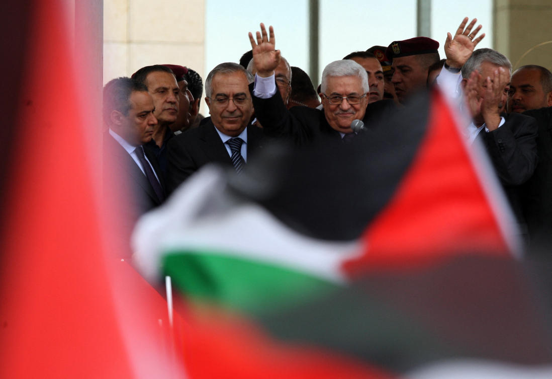 Palestinian president Mahmud Abbas waves to thousands of cheering Palestinians as they welcome their president at his Ramallah headquarters on September 25. (File/AFP)