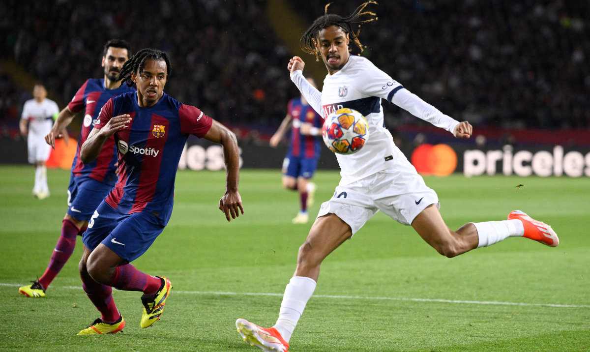 Barcelona's French defender Jules Kounde (L) fights for the ball with Paris Saint-Germain's French forward Bradley Barcola during the UEFA Champions League quarter-final second leg football match between FC Barcelona and PSG on April 16, 2024. (AFP)