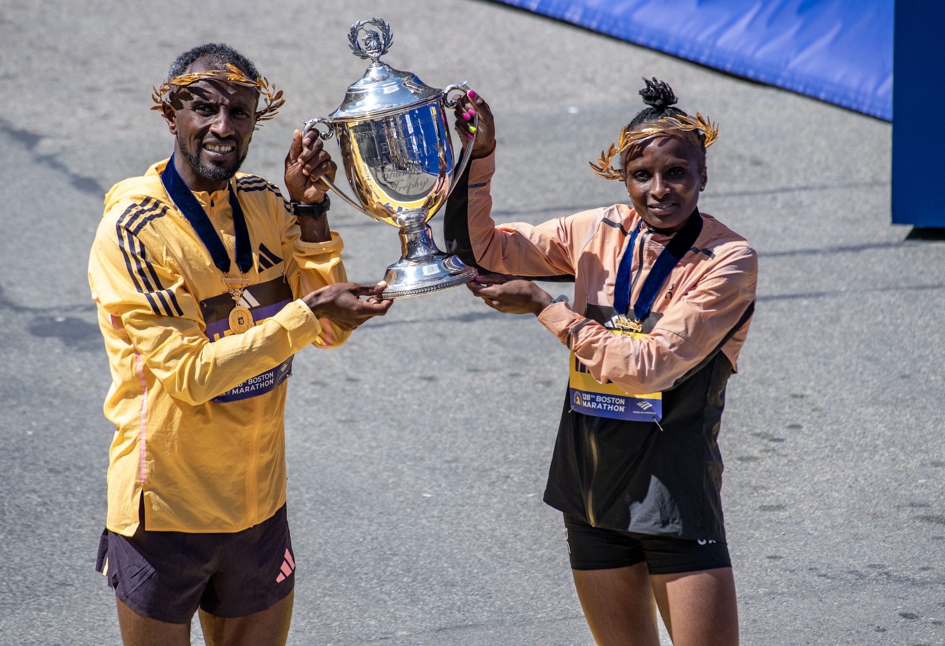 Sisay Lemma of Ethiopia and Hellen Obiri of Kenya hold the race trophy together after both taking first place in the men’s and women’s professional fields during the 128th Boston Marathon in Boston, Massachusetts, on April 15, 2024. (AFP)