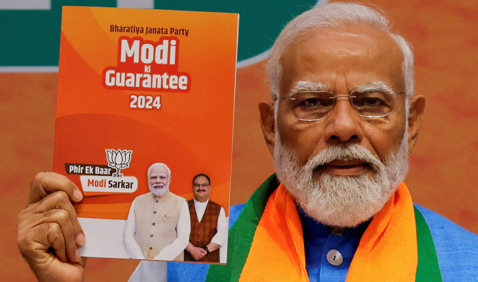 Indian Prime Minister Narendra Modi displays a copy of the ruling Bharatiya Janata Party's (BJP) election manifesto for the general election, in New Delhi, India, on April 14, 2024. (AP)