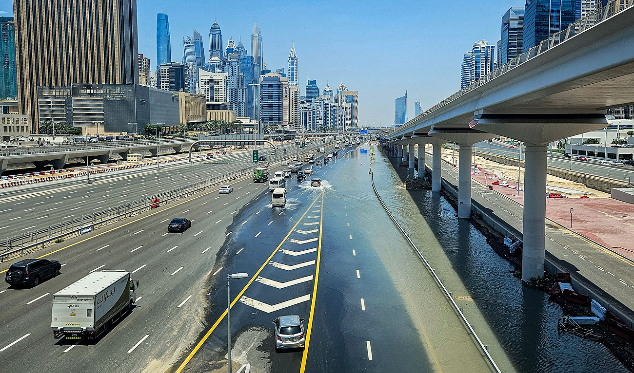 Vehicles move along the partially flooded Sheikh Zayed road (E11 highway) near the Dubai Marina Mall in Dubai on April 18, 2024, in the aftermath of heavy rains. (AFP)