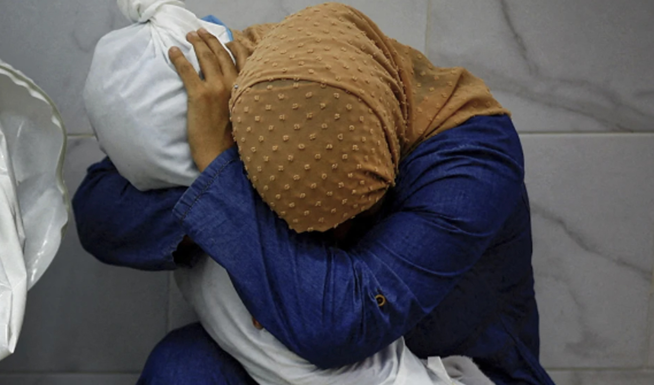 This image provided by World Press Photo and taken by Mohammed Salem of the Reuters news agency won the World Press Photo Award of the Year and shows Palestinian woman Inas Abu Maamar, 36. Embracing the body of her 5-year-old niece Saly, who was killed in an Israeli air strike, at Nasser hospital in Khan Younis in the southern Gaza Strip on October 17, 2023. (Reuters/WorldPressPhoto via AP)