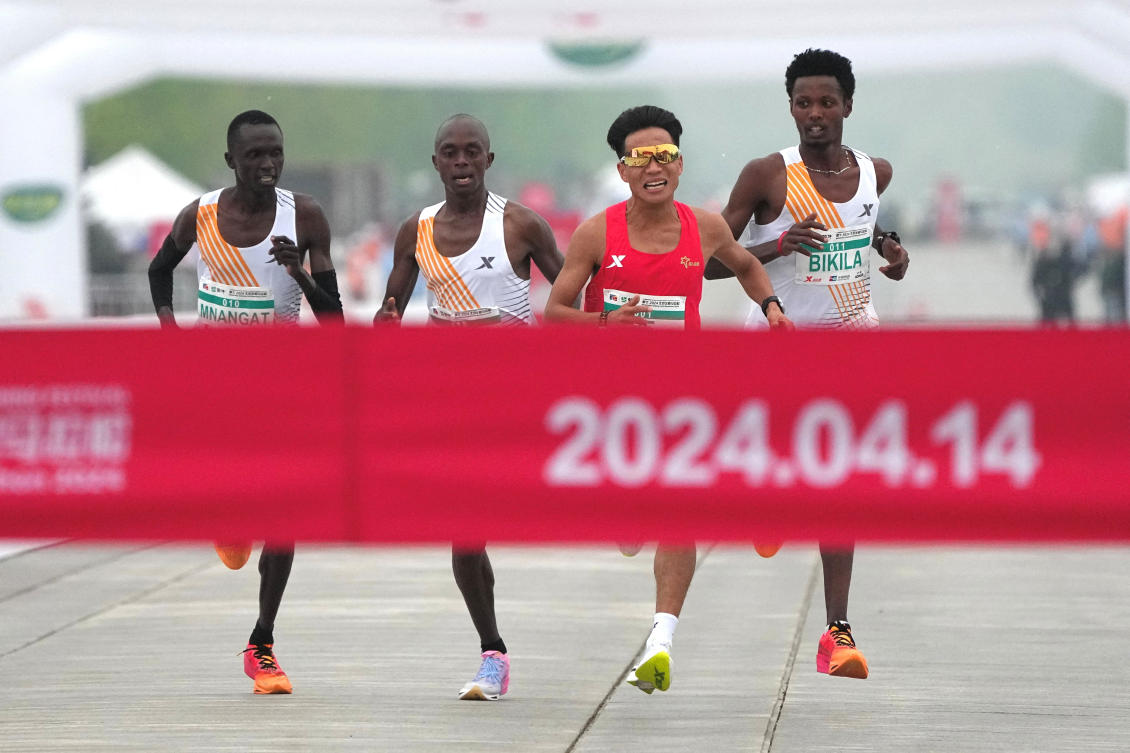 Chinese runner He Jie, second right, Ethiopian Dejene Hailu Bikila and Kenyans Robert Keter and Willy Mnangat take part in a half-marathon in Beijing, China April 14, 2024. (cnsphoto via Reuters)