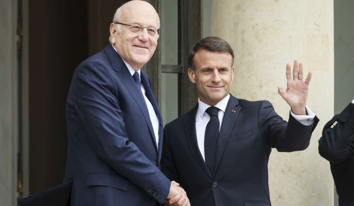 French President Emmanuel Macron, right, welcomes Lebanese caretaker Prime Minister Najib Mikati Friday, April 19, 2024 at the Elysee Palace in Paris. (AP)