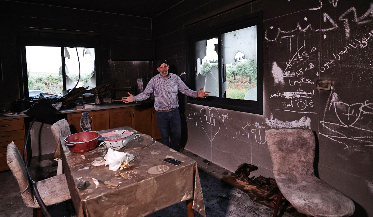 A Palestinian man stands inside his kitchen in the aftermath of an attack by Israeli settlers in occupied West Bank village of Al-Mughayyir near Ramallah. (AFP)