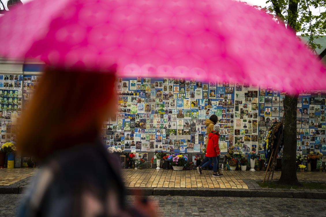 Ukrainian president Volodymyr Zelensky says that his country’s ‘warriors on the front lines’ would feel the benefit of the aid package. Above, people walk past a memorial wall in Kyiv with photographs of Ukrainian soldiers killed during the war. (AP)