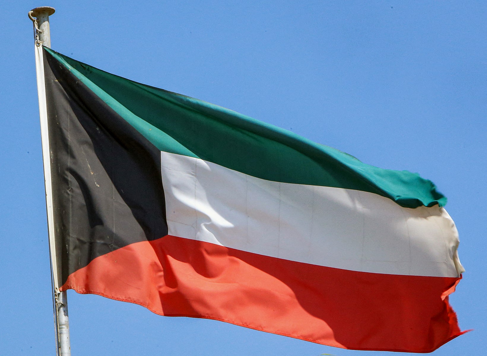 This picture taken on September 20, 2020 shows a Kuwaiti national flag flying from a mast in Kuwait City. (AFP)