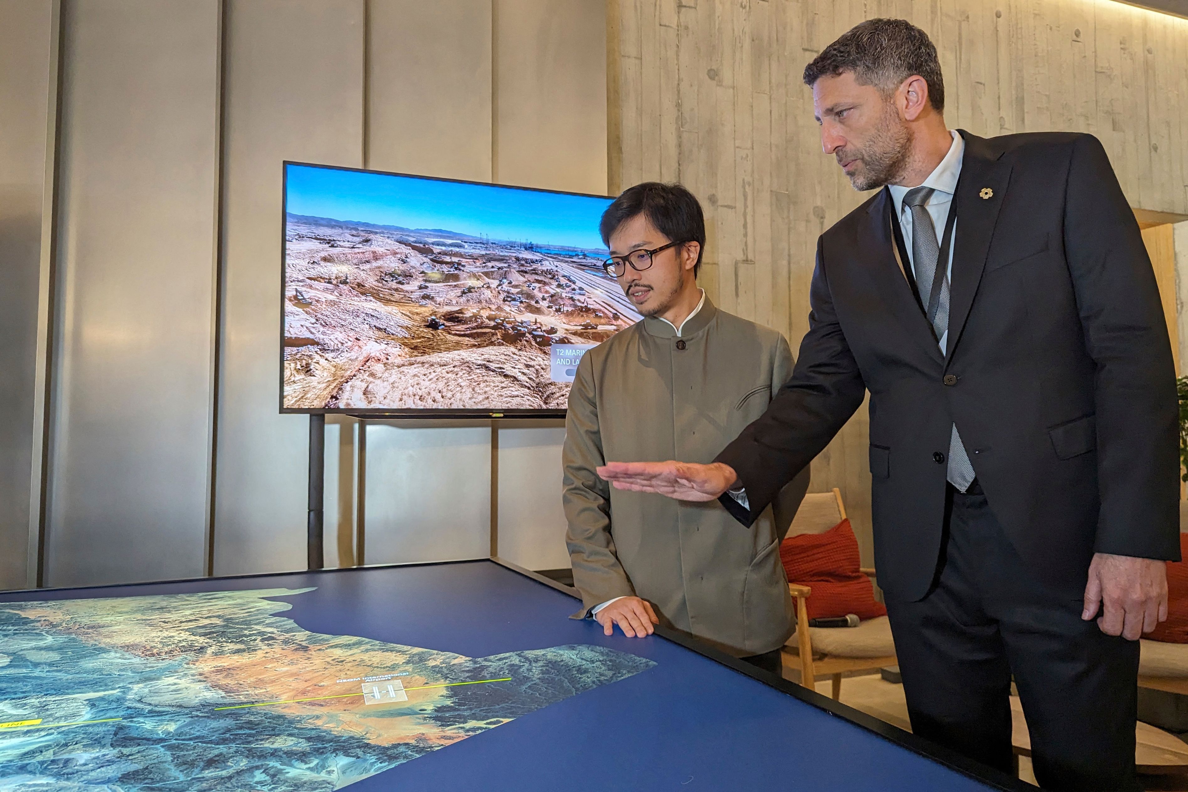 NEOM Executive Director Tarek Qaddumi gestures at a map showing the megacity’s sites as he stands beside Nicholas Ho, left, the top Hong Kong official responsible for implementing China's Belt and Road Initiative, at an exhibition at the M+ museum for visual culture in Hong Kong. AFP