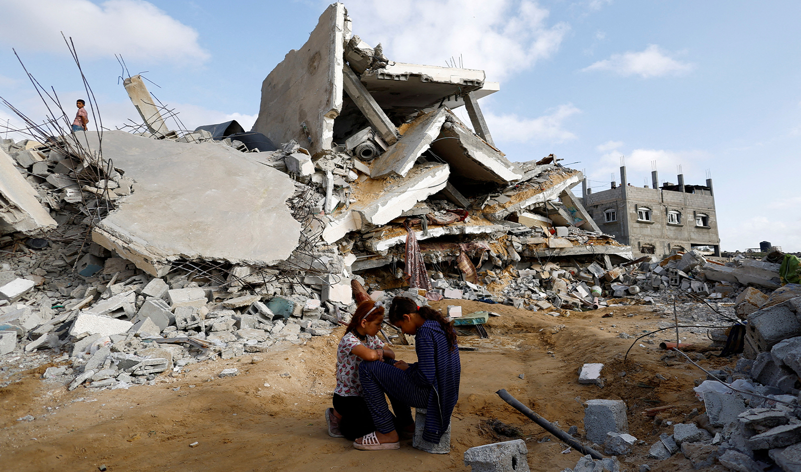 Palestinian children sit next to the site of an Israeli strike on a house, amid the ongoing conflict between Israel and the Palestinian Islamist group Hamas, in Rafah, in the southern Gaza Strip, on April 21, 2024. (REUTERS)