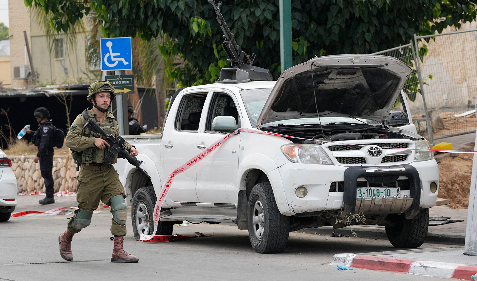 Israeli soldier walks by a pickup truck in Sderot, Israel, on October 7, 2023. (AP/File)
