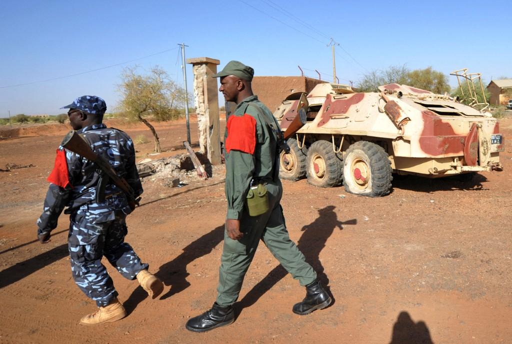 Malian soldiers walk on February 3, 2013 in Gao, near an armoured vehicle they abandoned when Islamist extremists took the city on March 31, 2012. (AFP)