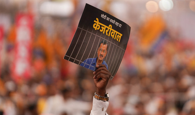 Supporters of India's opposition coalition comprising of various political parties named ‘INDIA’ or Indian National Developmental Inclusive Alliance, shouts slogans and displays a placard with a message on AAP chief and Delhi Chief Minister Arvind Kejriwal, during a rally held in New Delhi on March 31, 2024. (AFP/File)