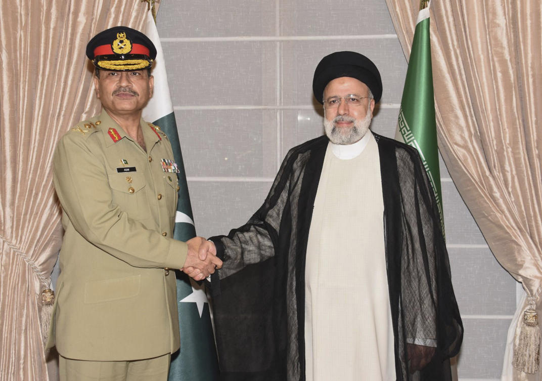 In this photo released by Inter Services Public Relations, Pakistan’s Army Chief General Asim Munir shakes hand with Iranian President Ebrahim Raisi prior to their meeting in Islamabad on Apr. 22, 2024. (AP)